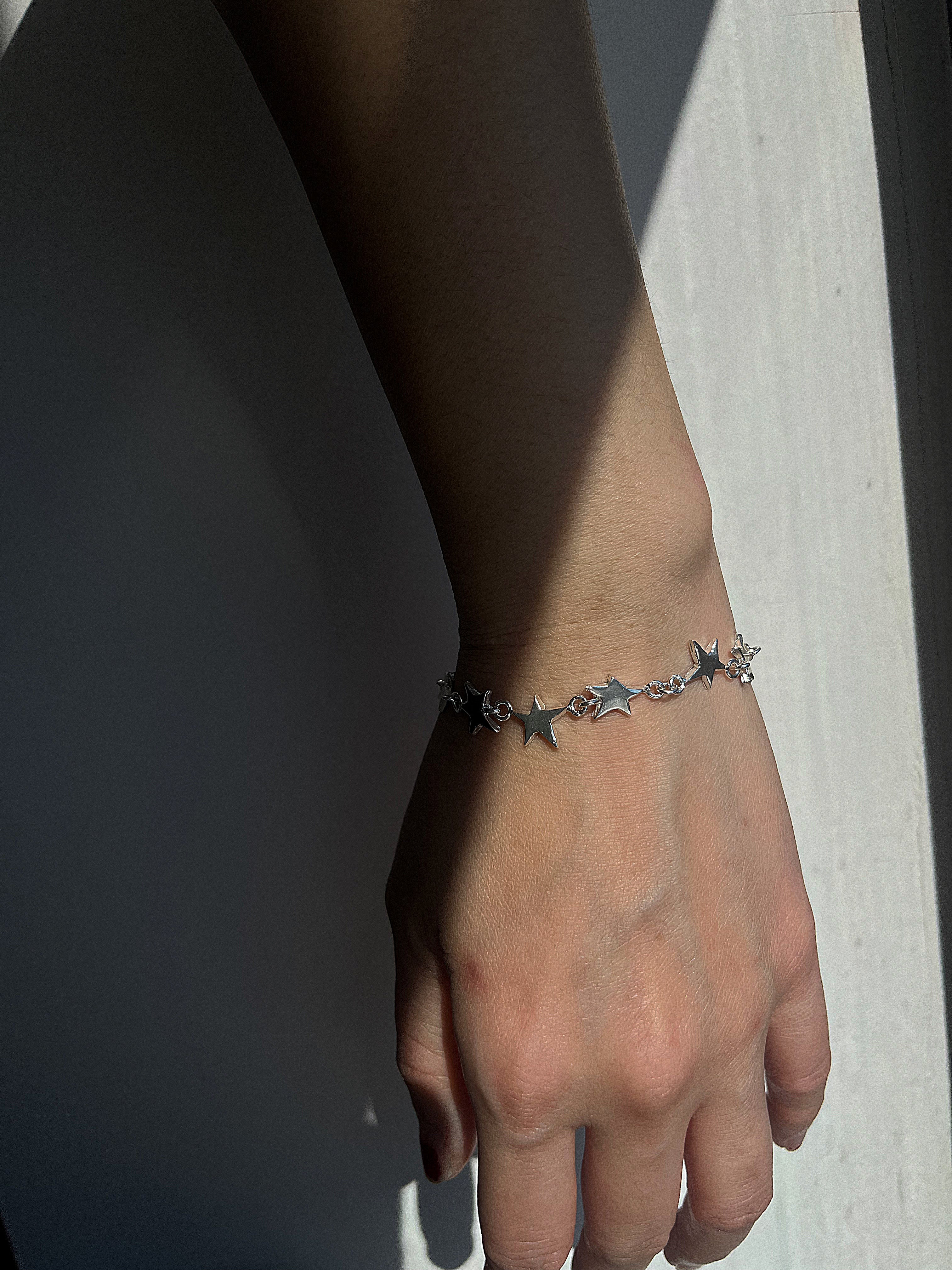 STERLING SILVER STAR LINK BRACELET WORN ON A WRIST